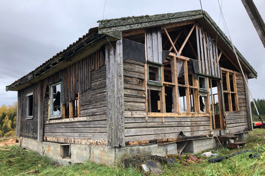 Forfallent hus i grønt landskap